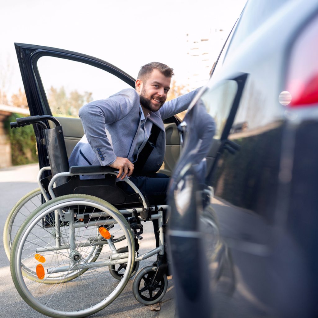 Handicapped man attempting to get in the car